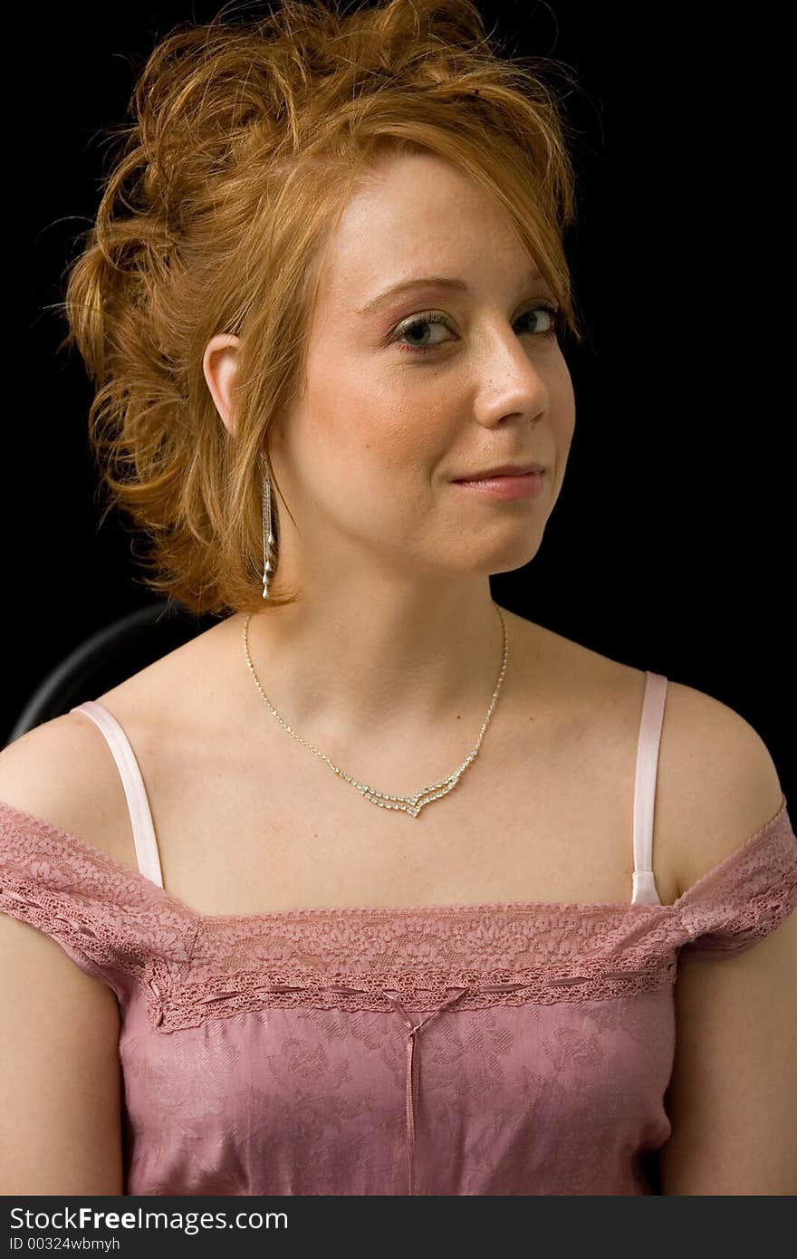 A young lady sports a curious grin as she poses for the portrait. A young lady sports a curious grin as she poses for the portrait.