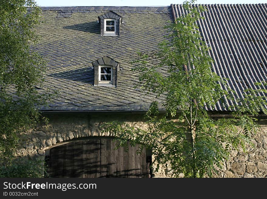 The front of a barn with trees