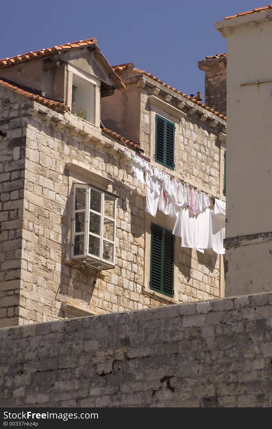 Clothes hanging outside of a stone apartment building to dry. Clothes hanging outside of a stone apartment building to dry