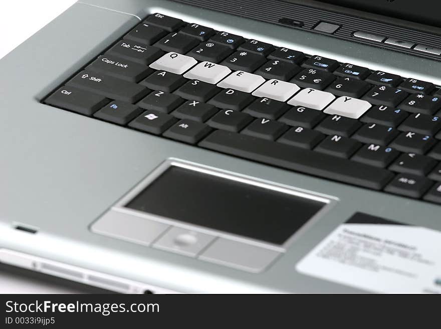 Close up of portion of a silver and black laptop with the keys, �QWERTY� highlighted. Close up of portion of a silver and black laptop with the keys, �QWERTY� highlighted