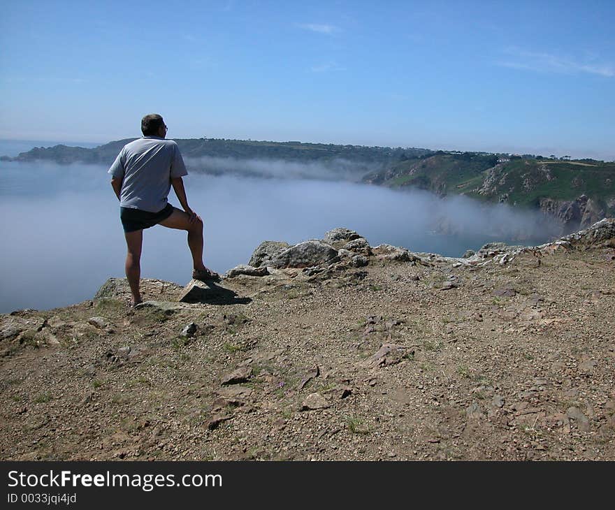 Man observing low cloud coming inland. Man observing low cloud coming inland