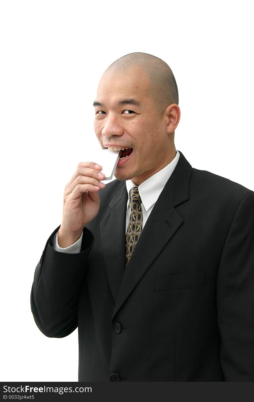 Oriental man in suit eating something square or rectangular in shape. Oriental man in suit eating something square or rectangular in shape