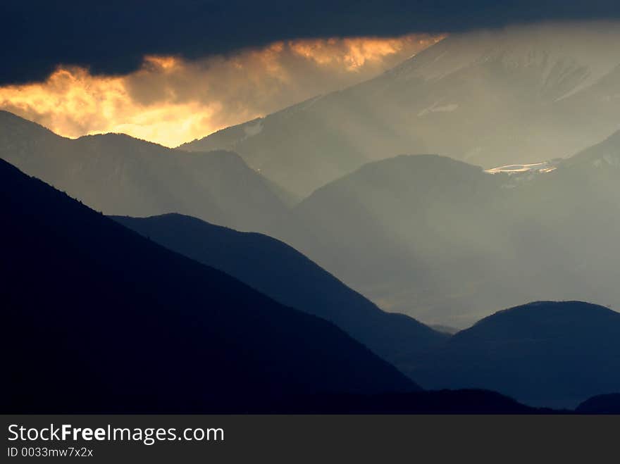 The moutain's silhouette frames the smoking sunlight