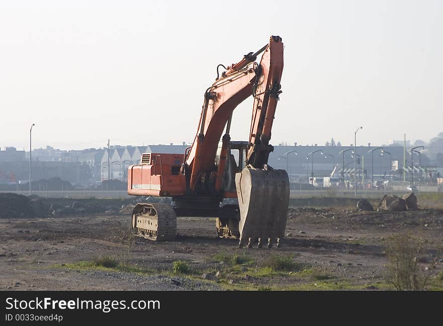 A backhoe sits idle at a new construction site.