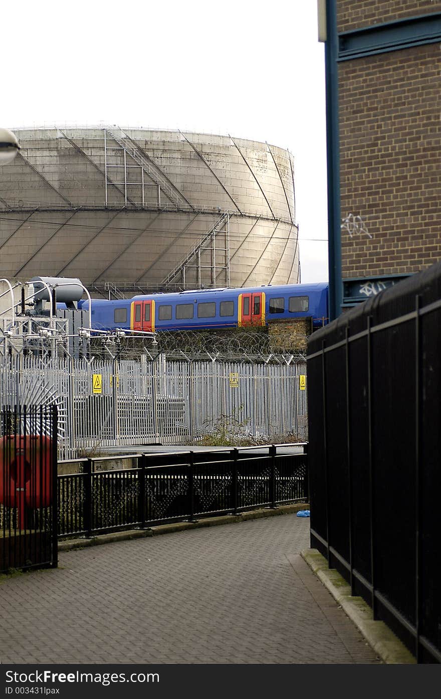 A South London view showing a Gasometer, power transformers, canal, footpath and overground train. A South London view showing a Gasometer, power transformers, canal, footpath and overground train