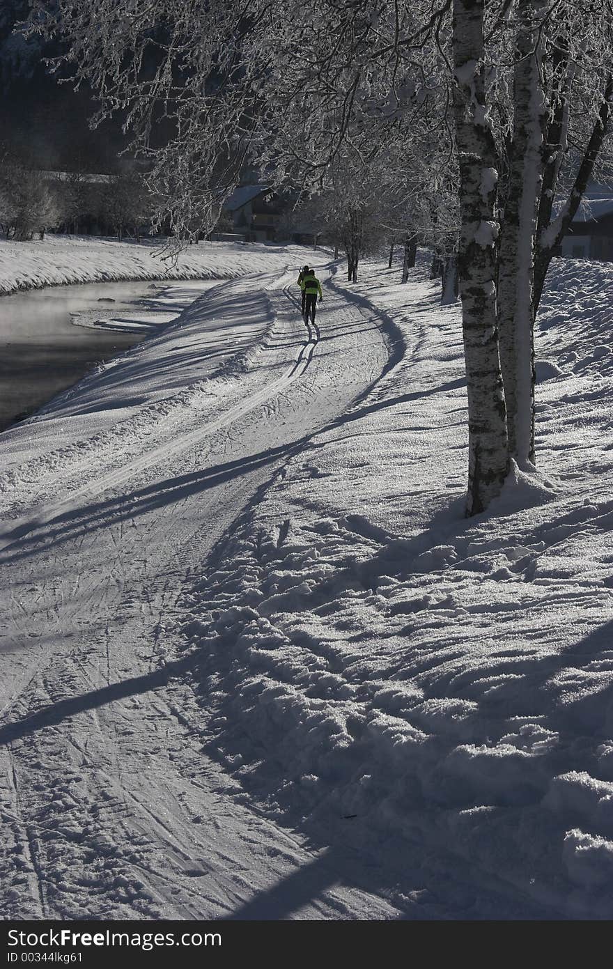 Cross-country skiing along a river at a cold winter morning. Cross-country skiing along a river at a cold winter morning