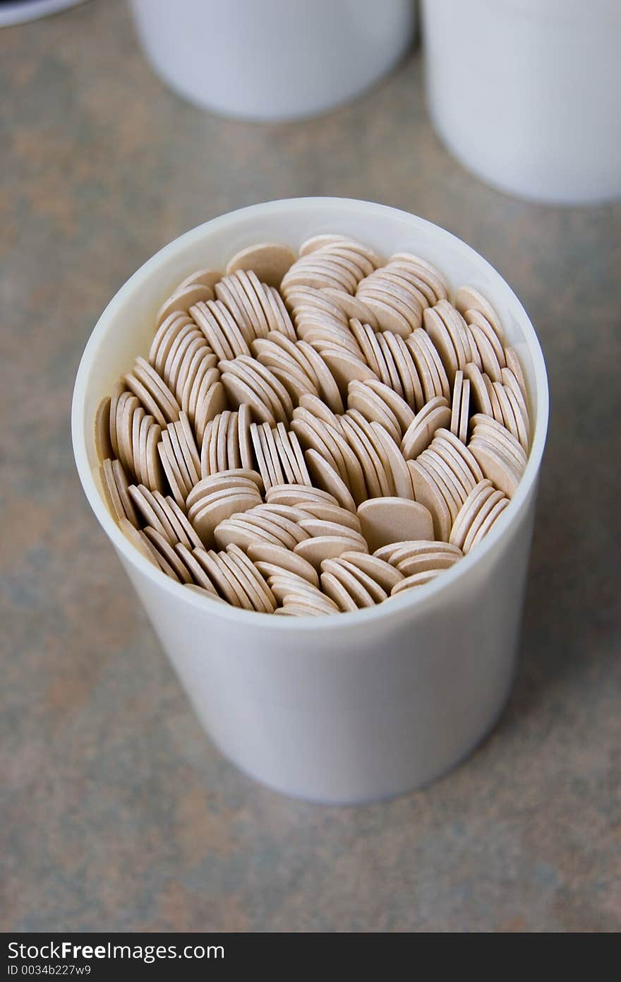 A container of tongue depressors on the counter in an examination room.