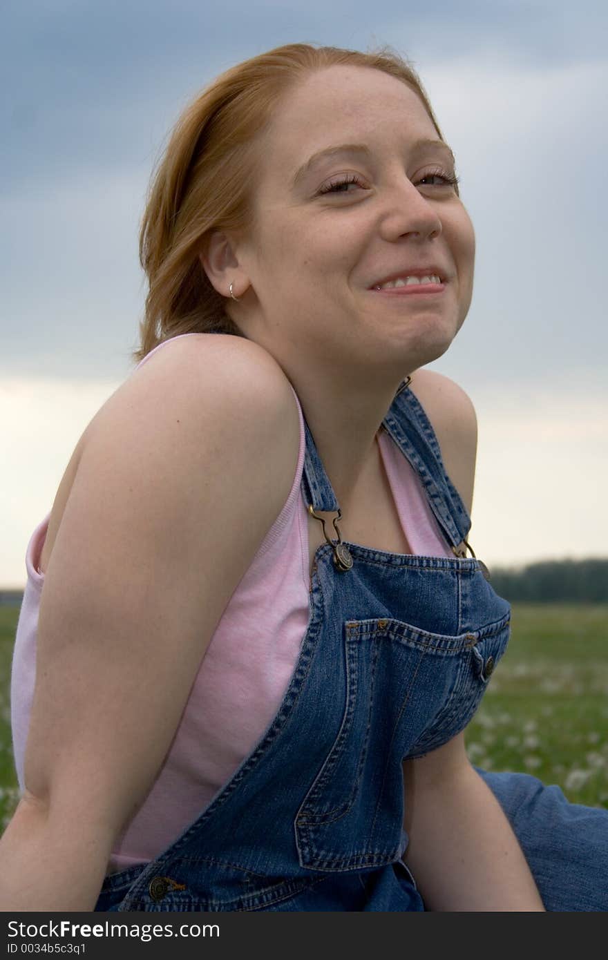 A girl wearing coveralls and sporting a pretty smile. A girl wearing coveralls and sporting a pretty smile.