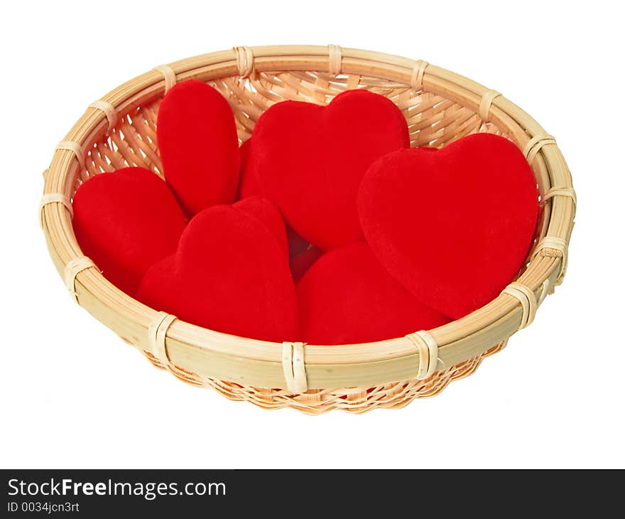 Little basket with plush hearts in it over white background. Little basket with plush hearts in it over white background