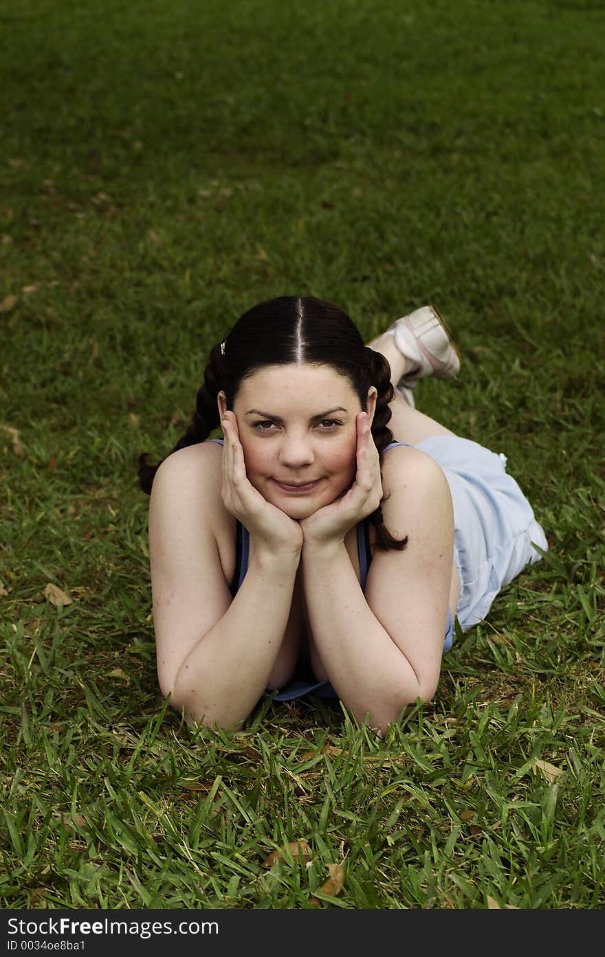 Young girl daydreaming in grass