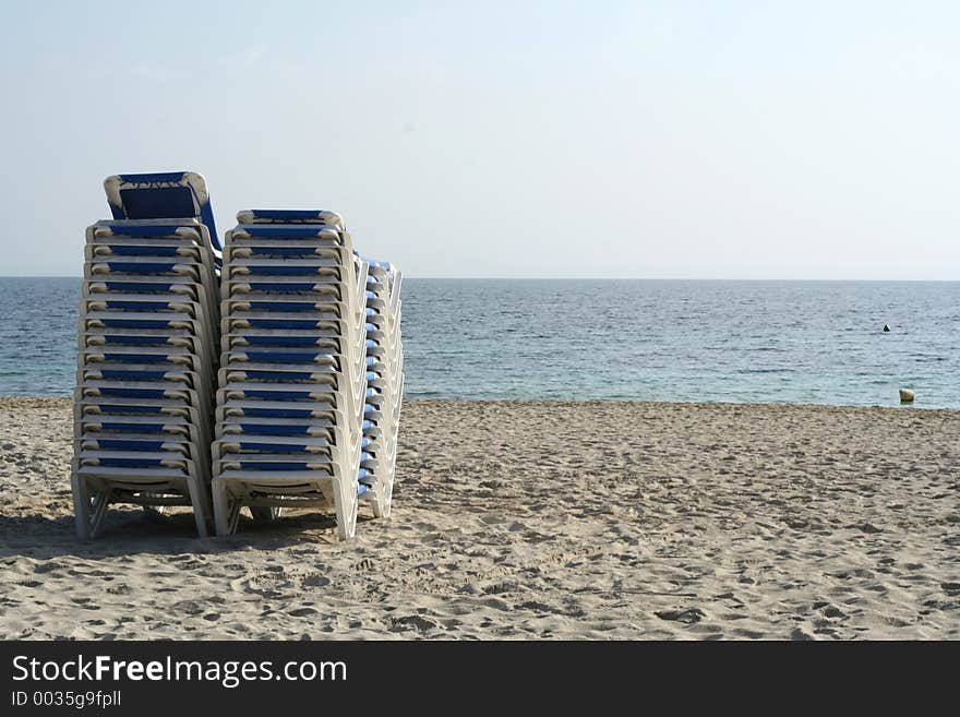 Sunbeds piled up at end of day on beach