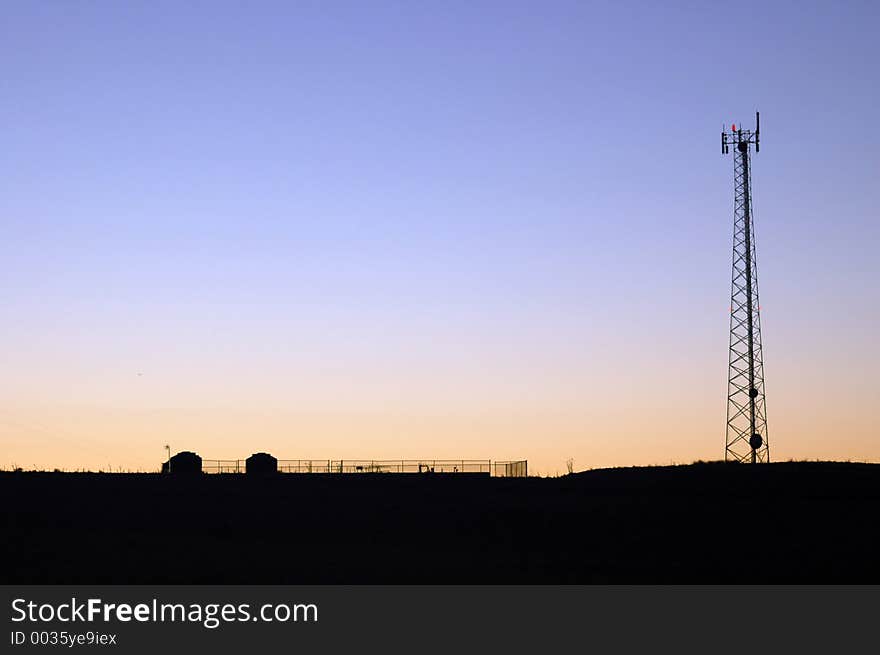 A lone communications tower at sunset