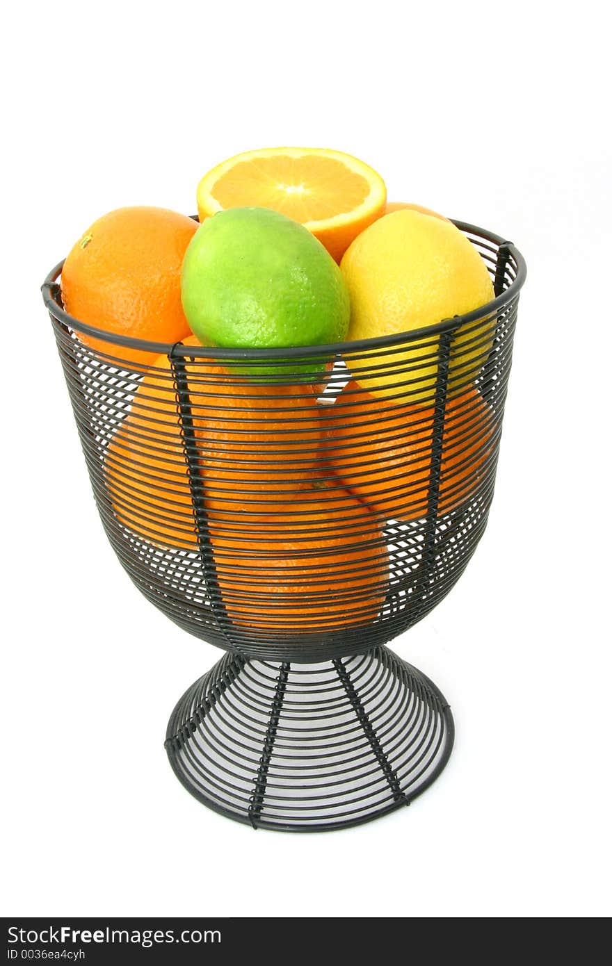 Citrus fruit in wire basket over white