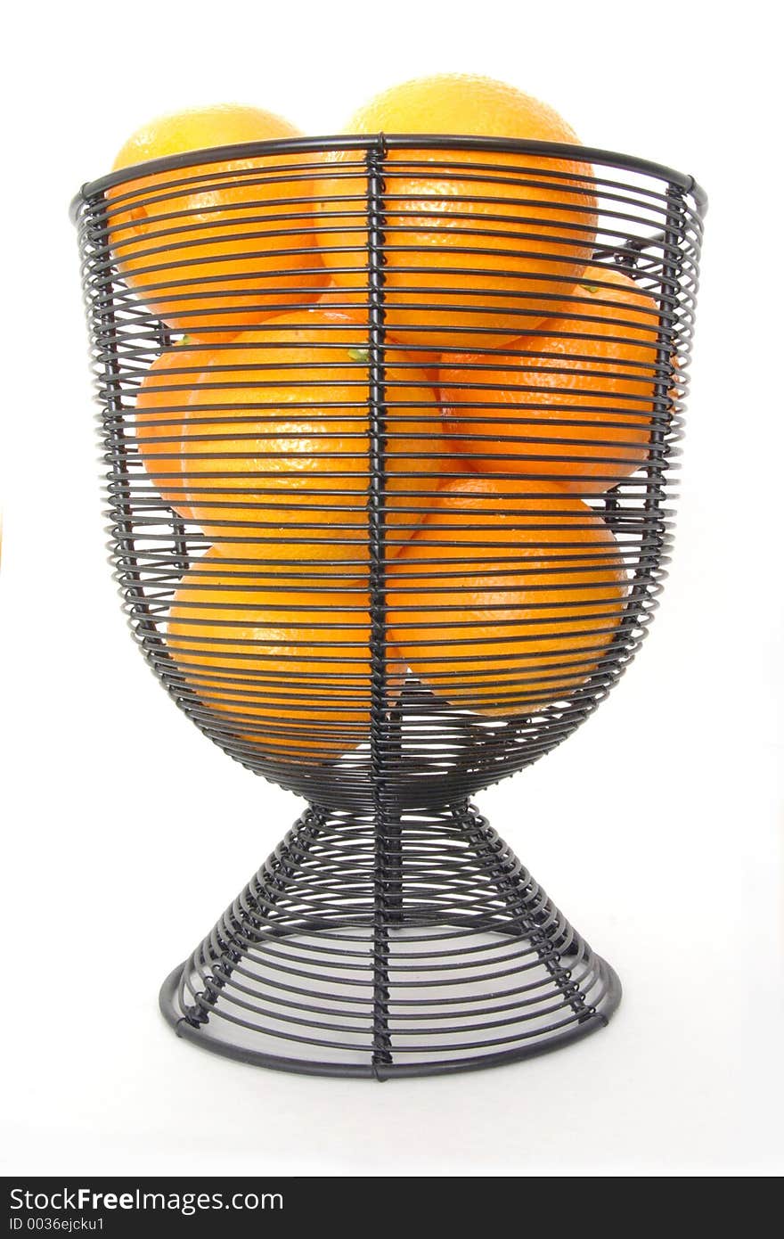 Oranges in a wire basket over white