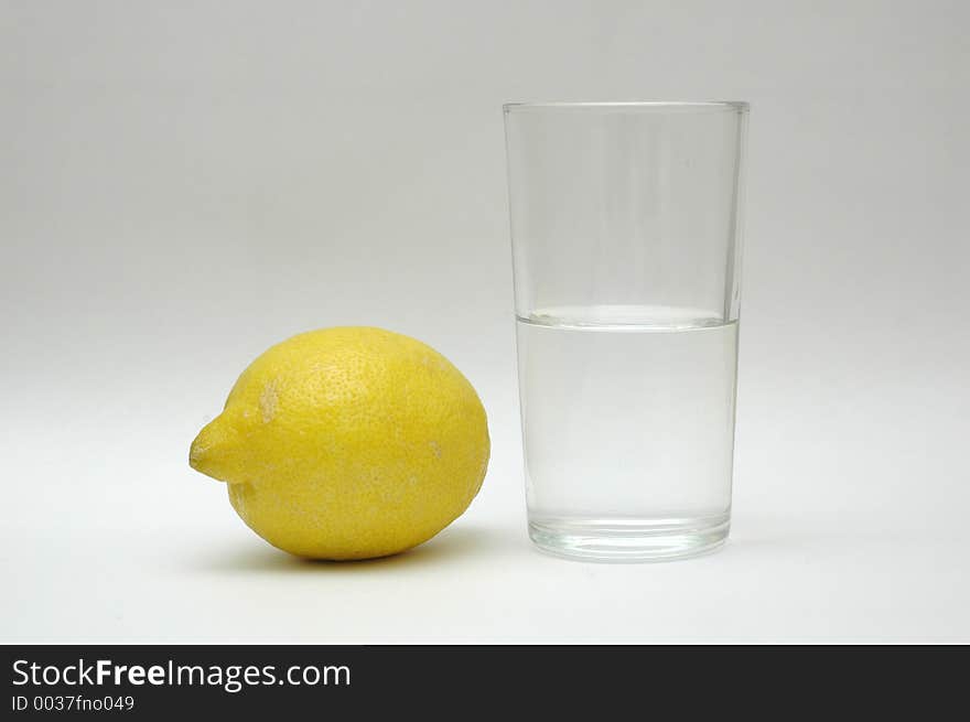 Yellow lemon and a glass of water. Yellow lemon and a glass of water.