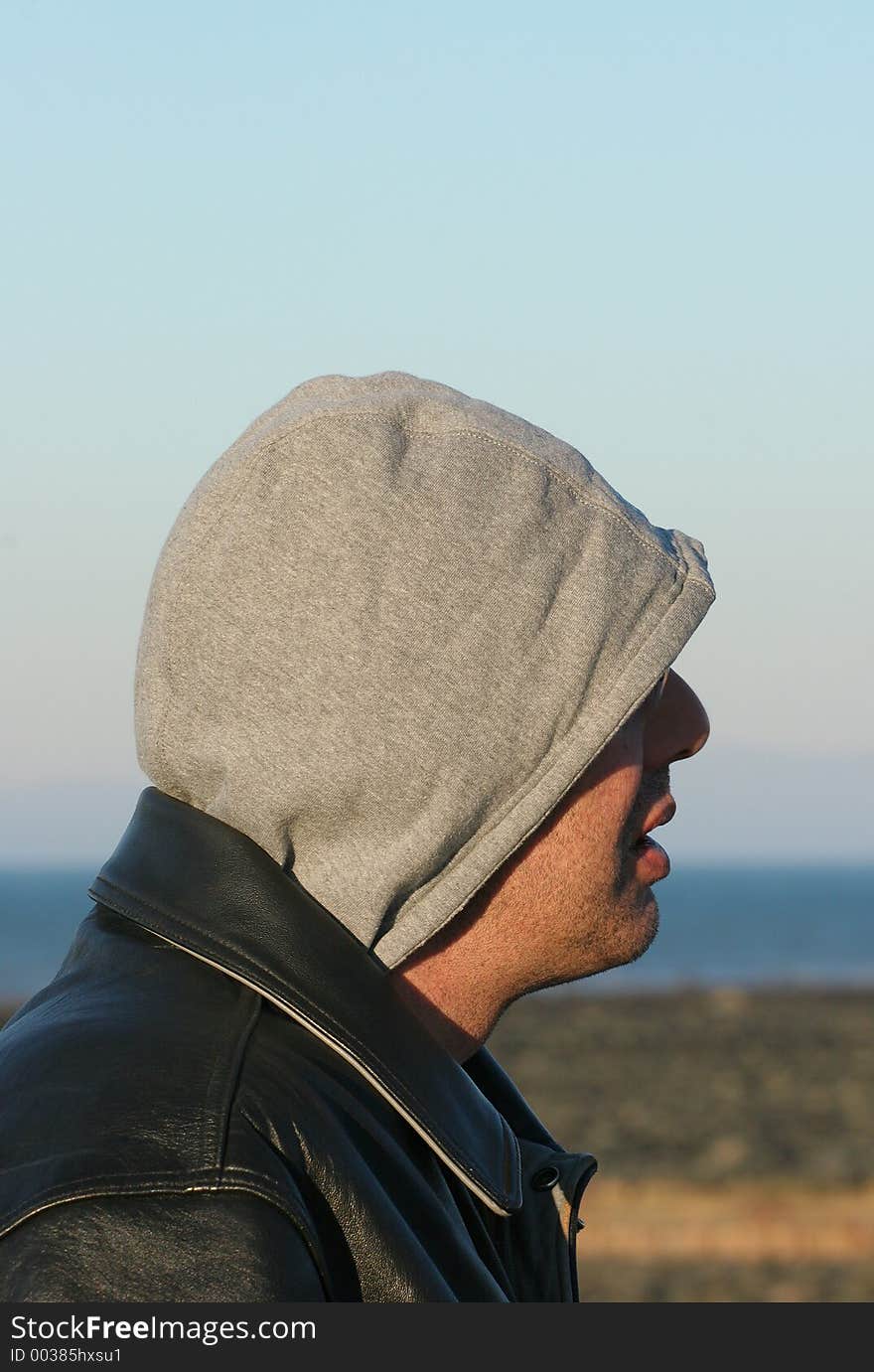 Profile of a man wearing a leather jacket and a hood. Profile of a man wearing a leather jacket and a hood.