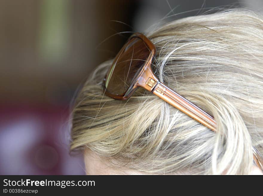 Sunglasses balanced on blonde hair. Sunglasses balanced on blonde hair