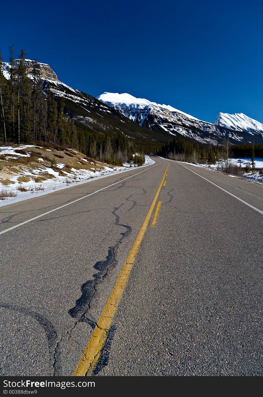 A scenic highway cuts into the mountains in mid winter. A scenic highway cuts into the mountains in mid winter.