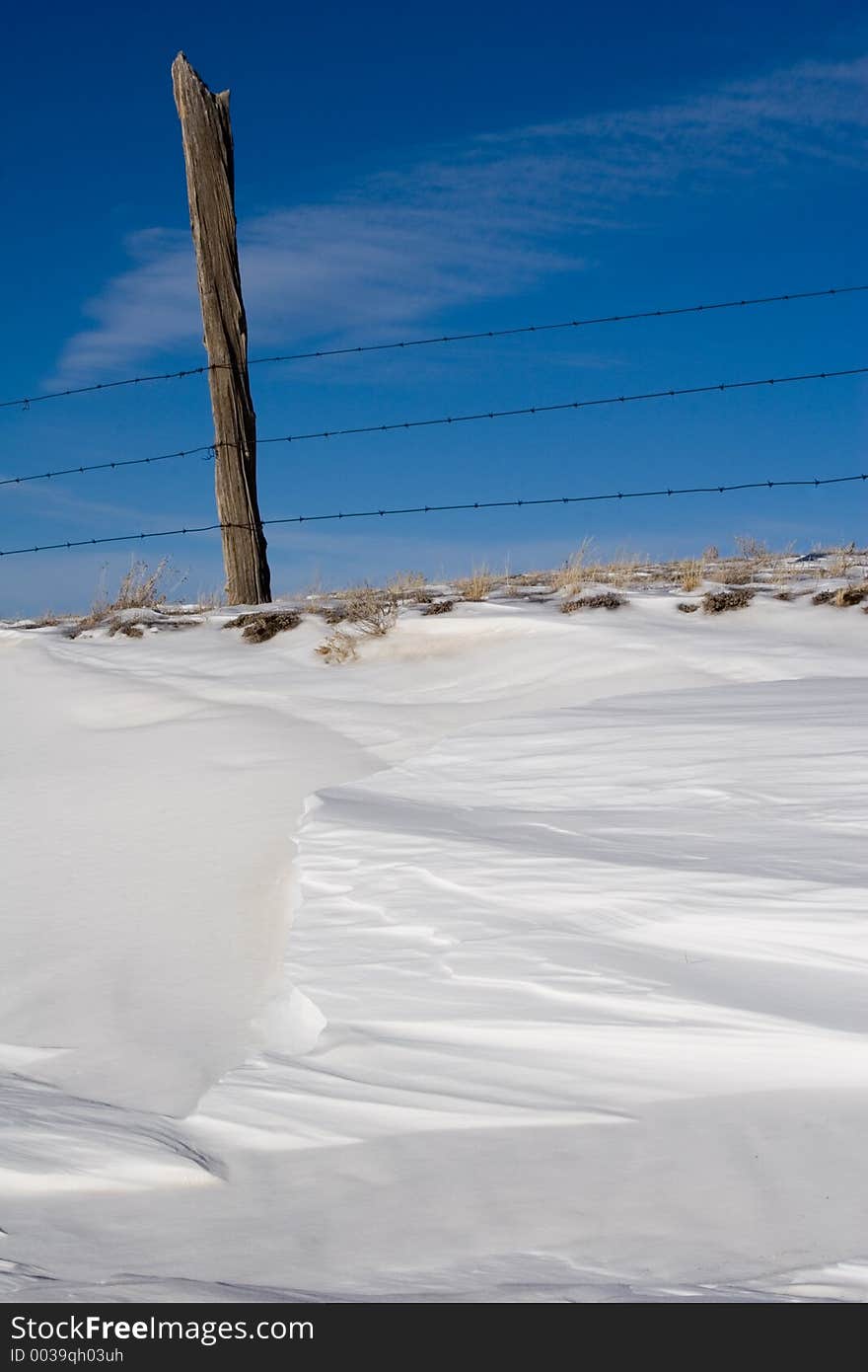 Barbed wire fence, fencepost and drifts of snow mark the beginning of winter in the South Park area of central Colorado. Barbed wire fence, fencepost and drifts of snow mark the beginning of winter in the South Park area of central Colorado.