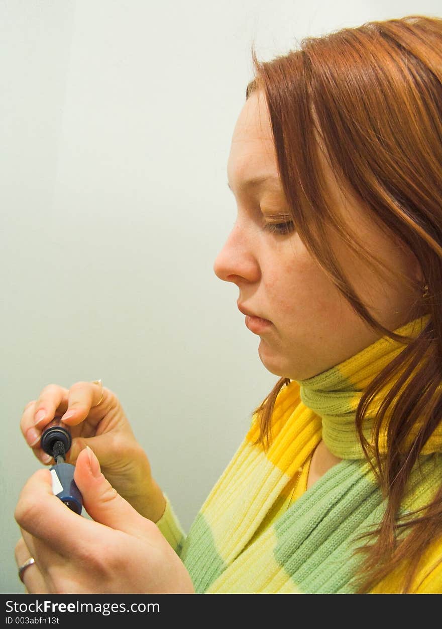 The girl paints eyelashes