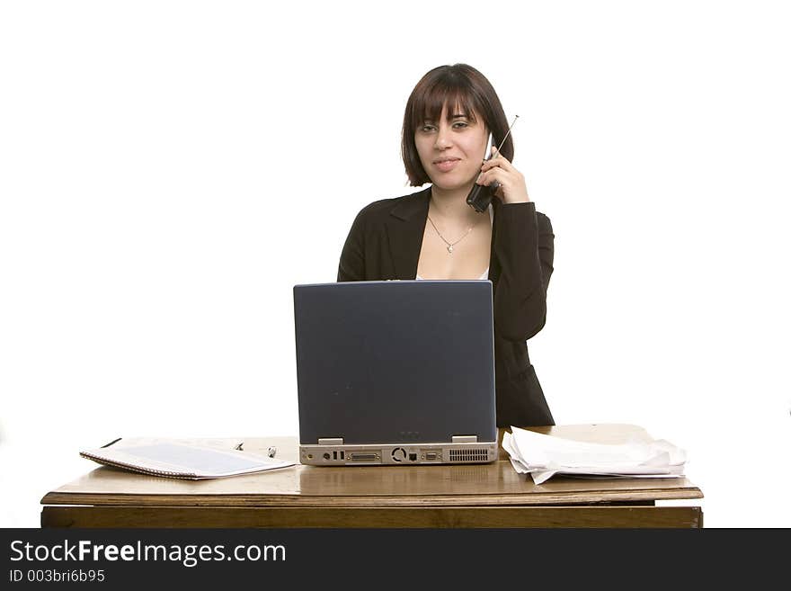 Young woman working on a computer and talking on the telephone. Young woman working on a computer and talking on the telephone