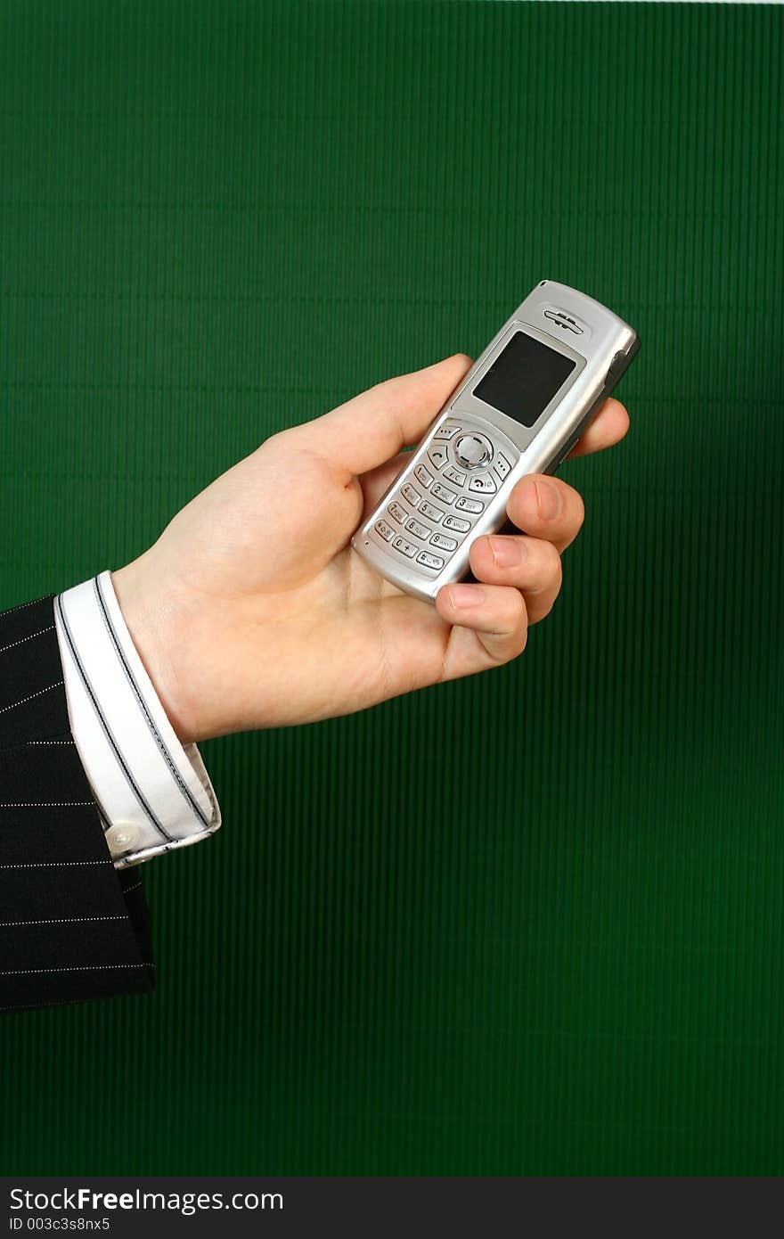 A businessman holding a telephone in his hand. A businessman holding a telephone in his hand