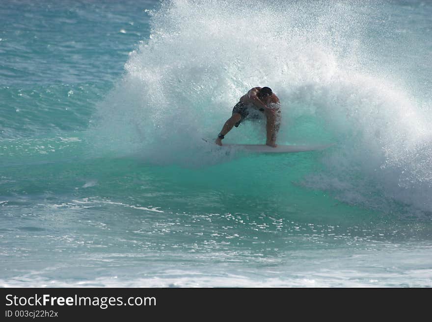 Surfer does a vicious turn on a small wave. Surfer does a vicious turn on a small wave.