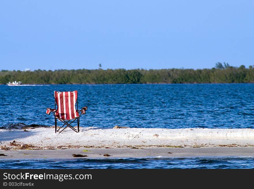 Pool chair abandoned on a deserted sandbar. Pool chair abandoned on a deserted sandbar