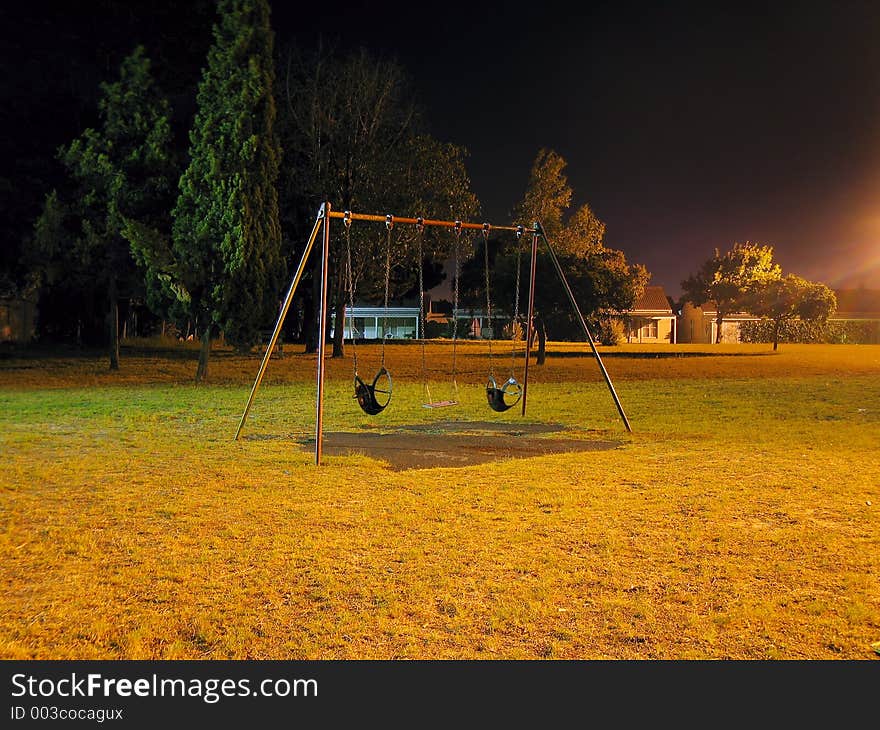 Urban park swing-set at night. Urban park swing-set at night.