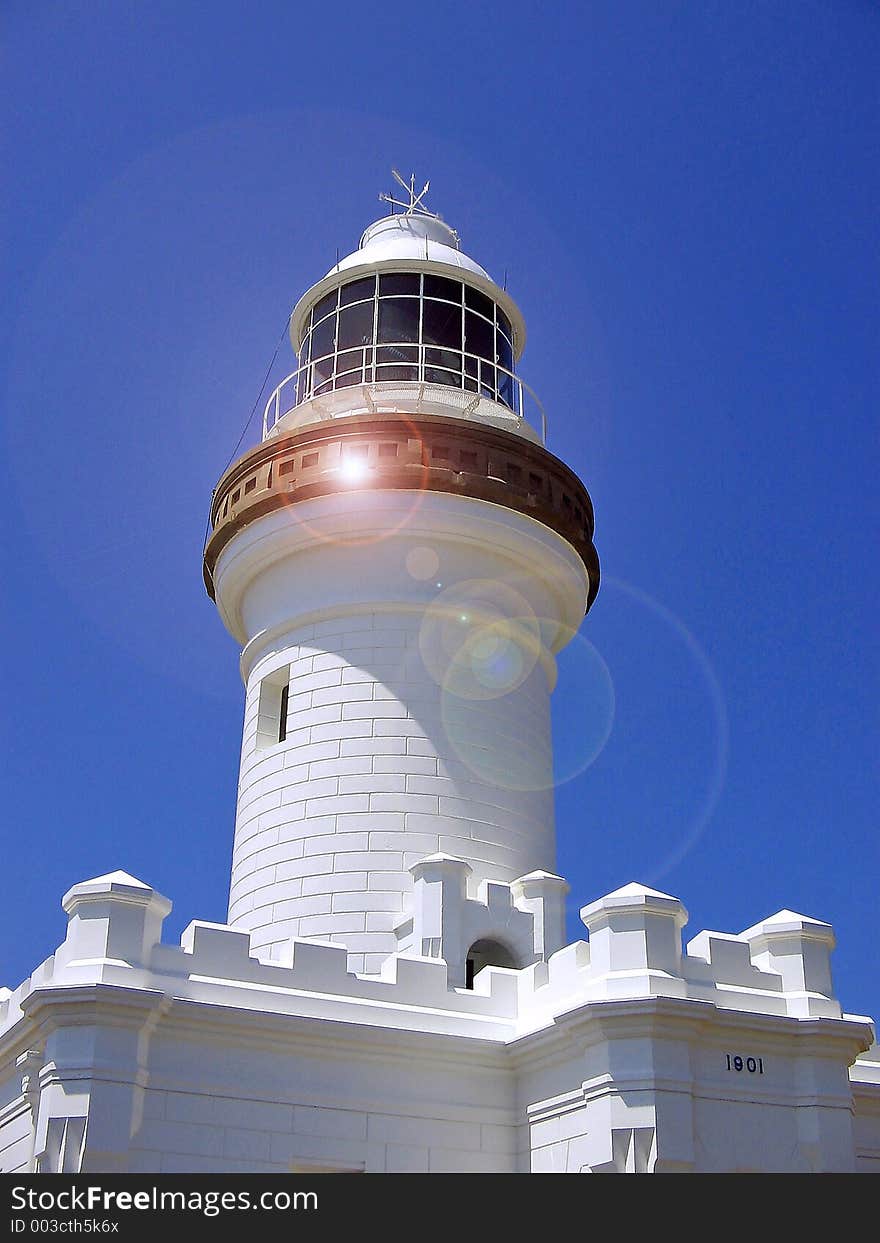 Lighthouse with lense flare to emphasise the 'light' beam.Copy space at the top in the sky. Lighthouse with lense flare to emphasise the 'light' beam.Copy space at the top in the sky.