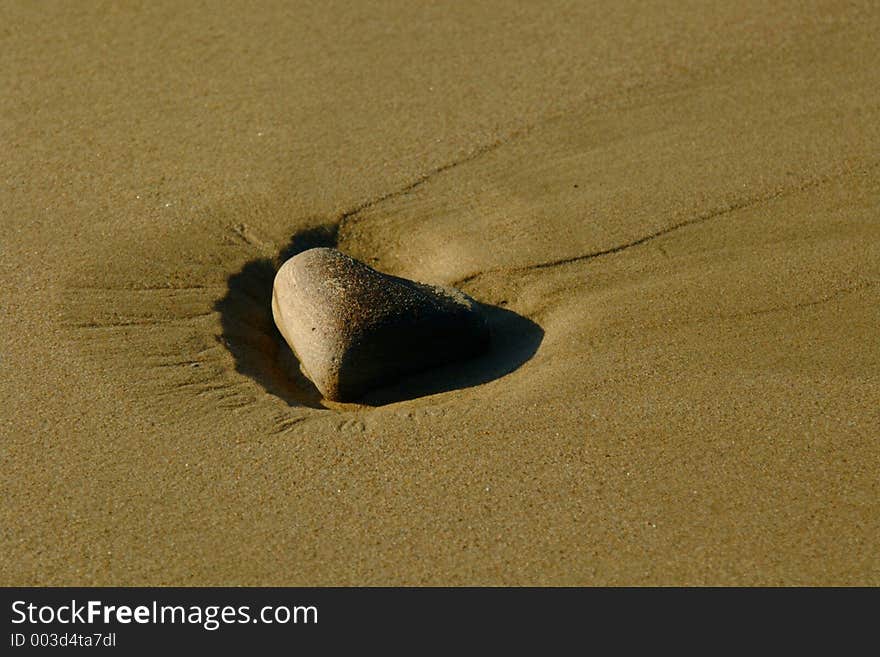 Lone Stone On Sandy Beach