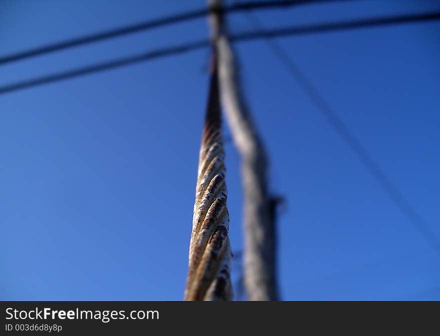 Shallow field of depth. Limited focus on this power line metal pole meeting the power line at the shallow focal point. Shallow field of depth. Limited focus on this power line metal pole meeting the power line at the shallow focal point.