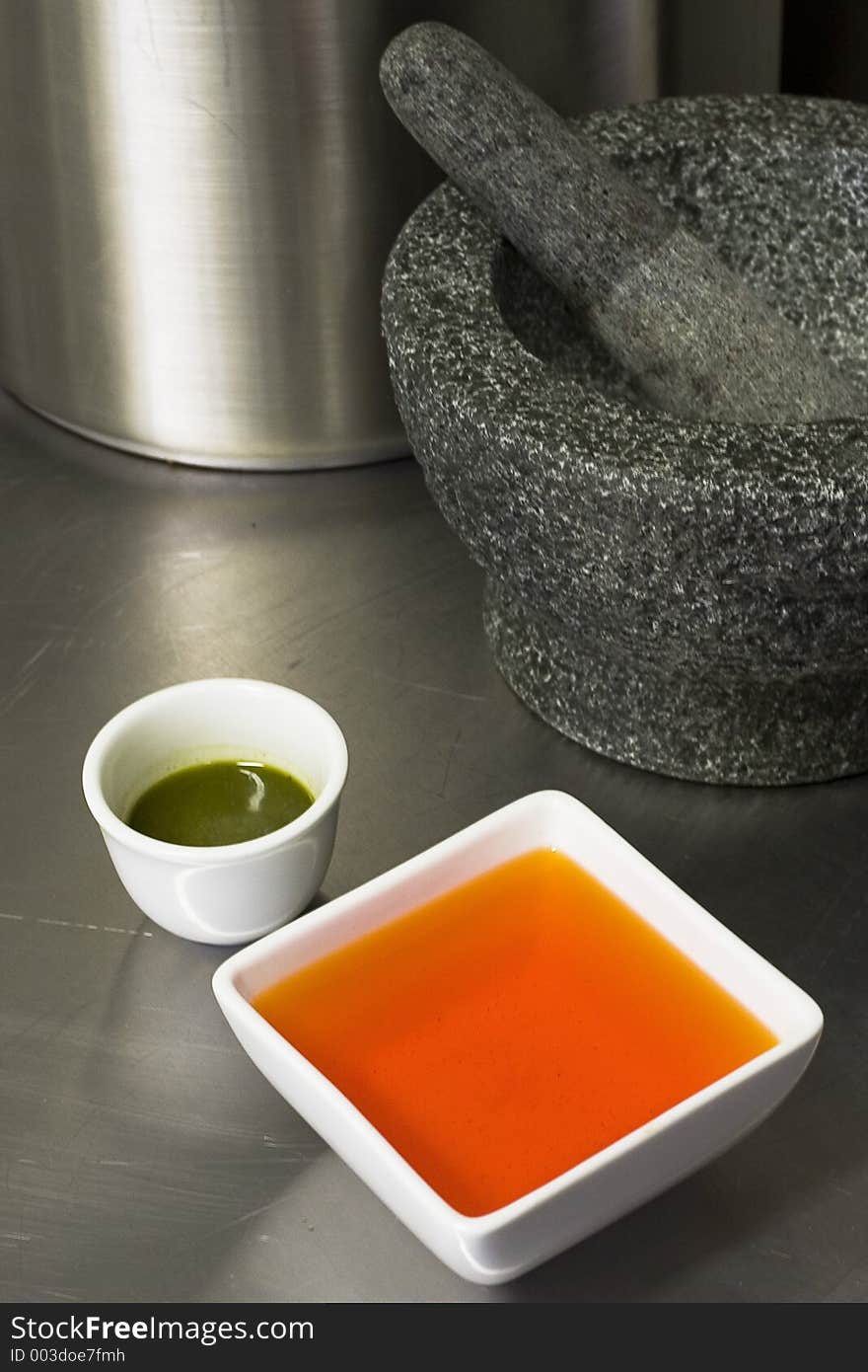 Sauces infront of a morter & pestle. Kitchen setting.