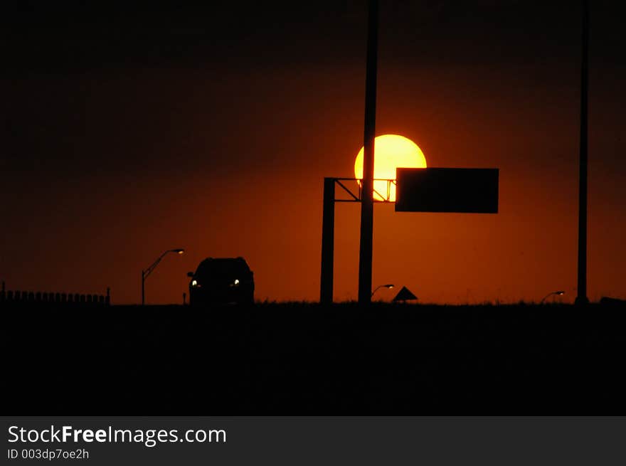 The sun goes down over the highway on a hot hazy summer day in Texas. The sun goes down over the highway on a hot hazy summer day in Texas.