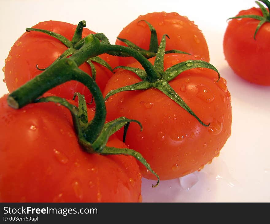 Shot of a few tomatoes over white.