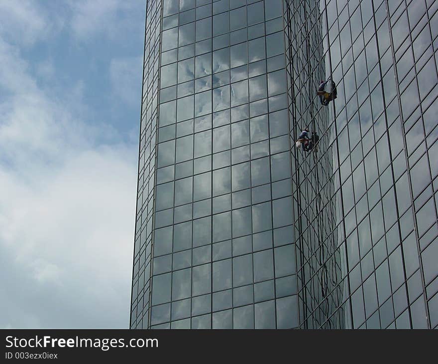 Window washers on a skyscraper. Window washers on a skyscraper