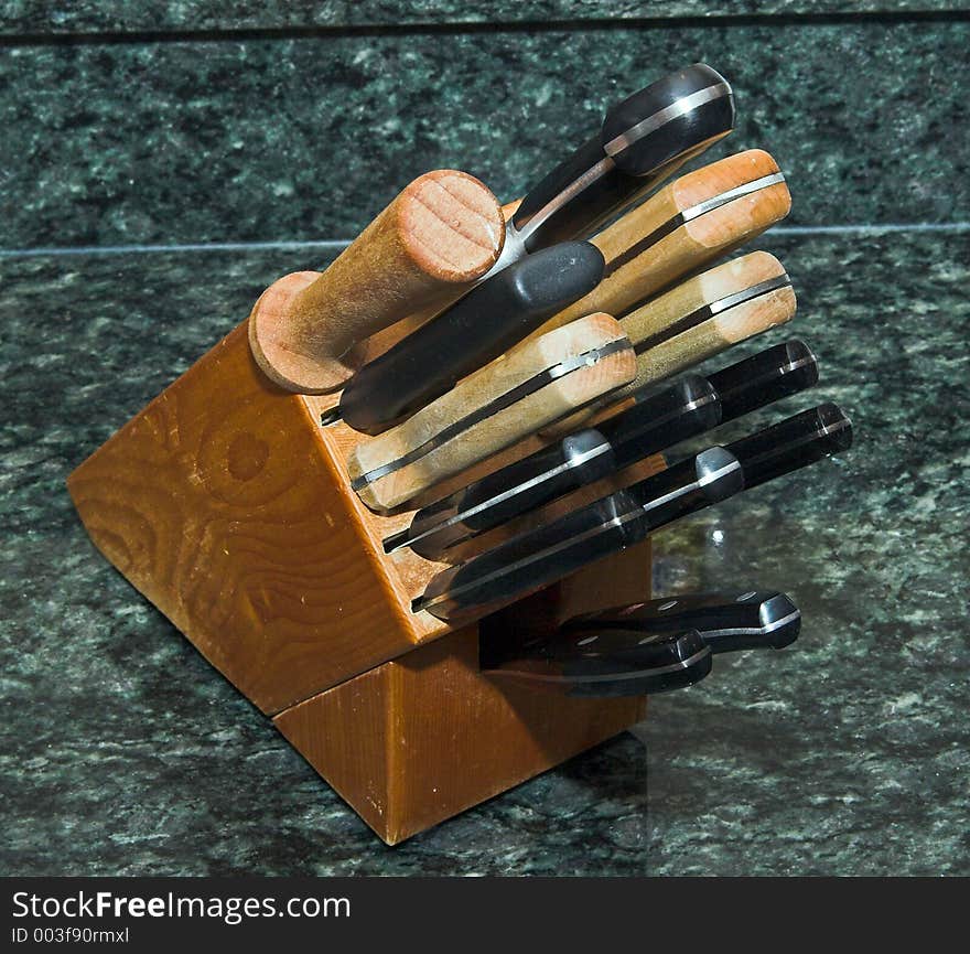 Knives in a Butcher's Block against a green granite background