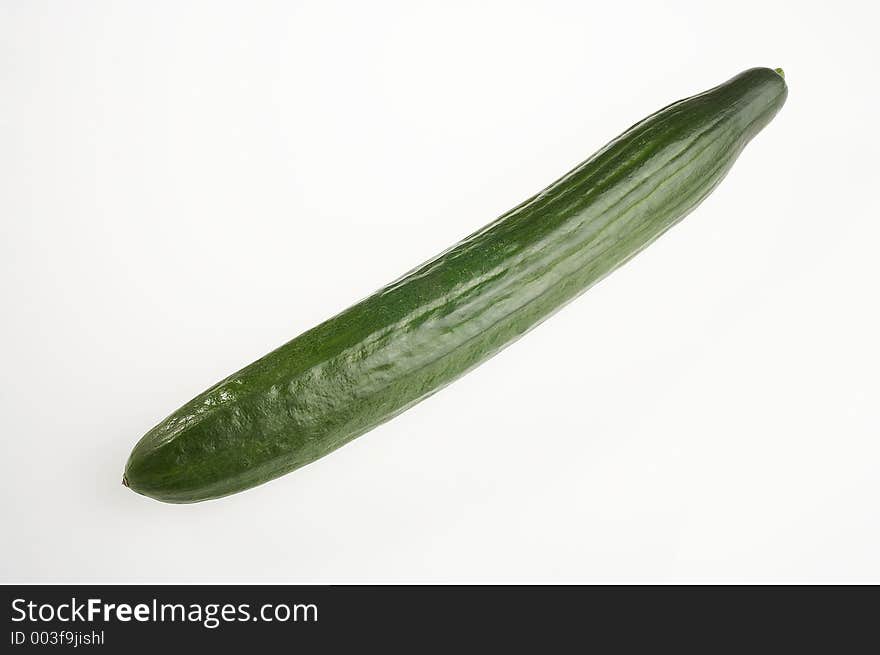 Long green cucumber on white background - lange gruene Gurke auf weissem Hintergrund. Long green cucumber on white background - lange gruene Gurke auf weissem Hintergrund