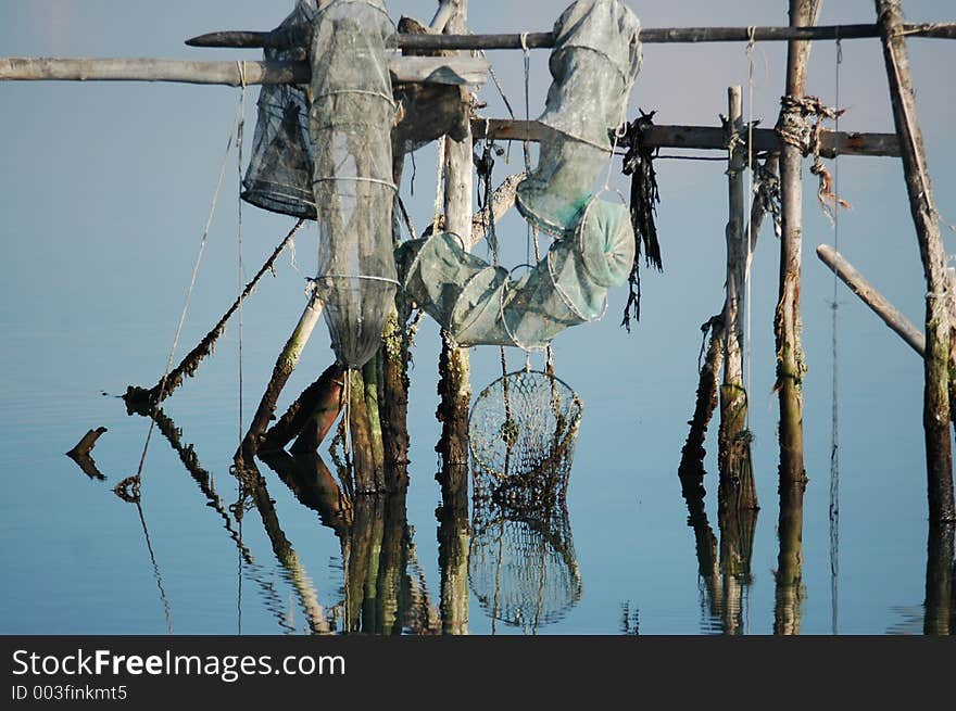 Fish nets on water with reflection