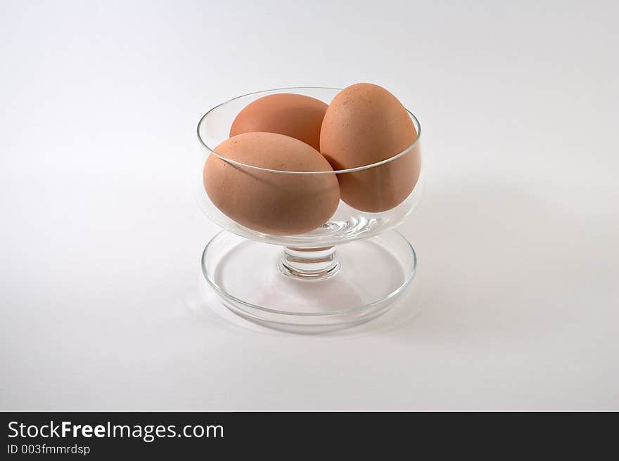 Fresh eggs in glass dish and white background. Fresh eggs in glass dish and white background