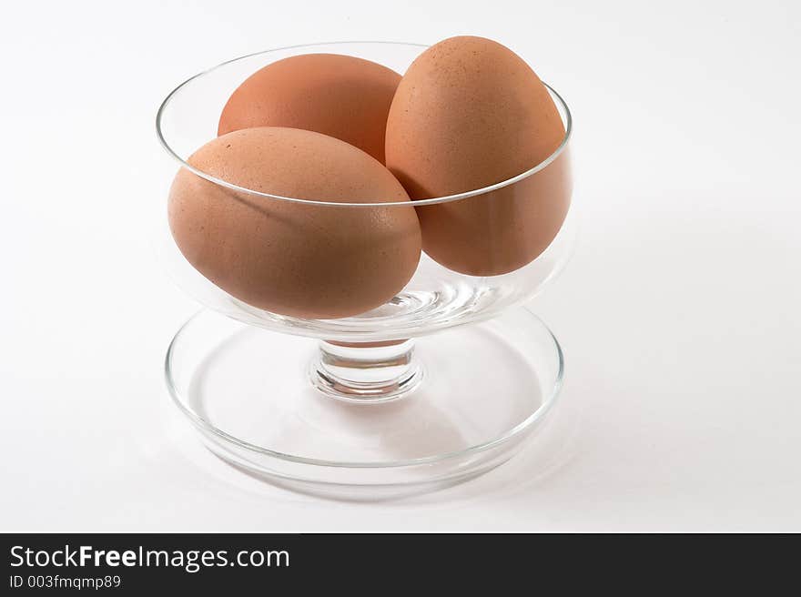 Eggs in a glass sundae dish on a white background. Eggs in a glass sundae dish on a white background