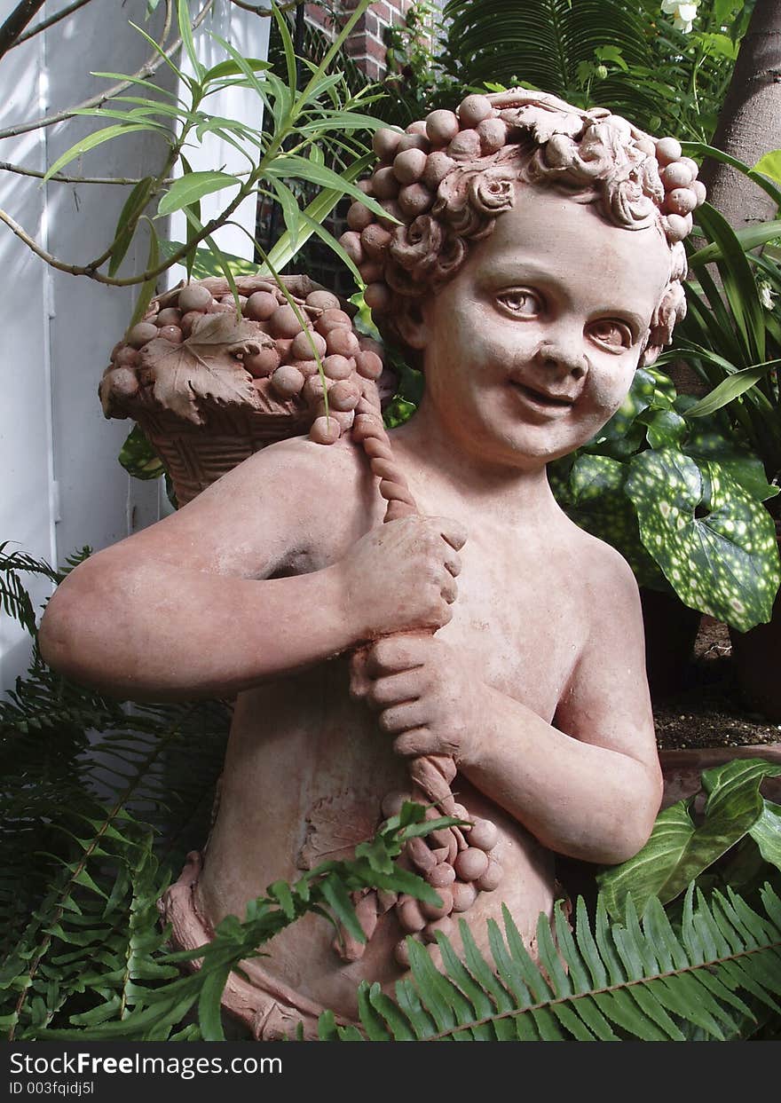 Terra cotta sculpture of a boy with grapes. Terra cotta sculpture of a boy with grapes