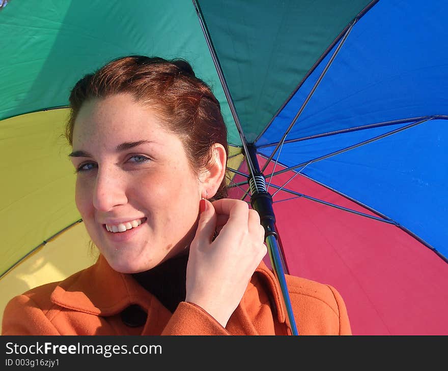 Smiling girl with a rainbow umbrella. Smiling girl with a rainbow umbrella