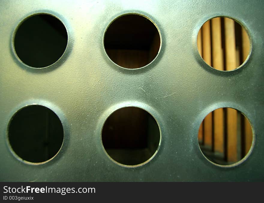 Close-up of sheet of metal with holes in urban building. Close-up of sheet of metal with holes in urban building