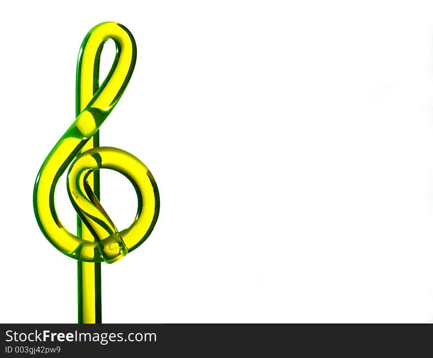 Yellow glass treble clef sign on white background