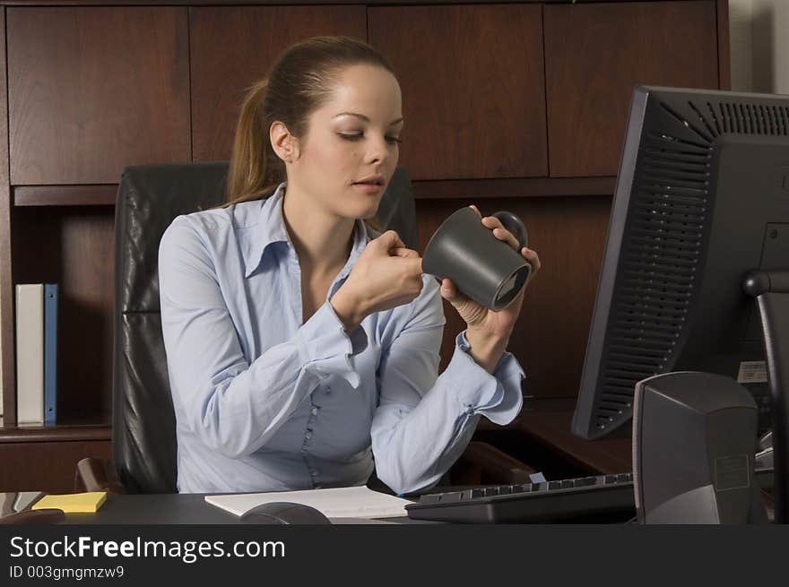 Female employee moments before going back to work after a brief coffee break. Female employee moments before going back to work after a brief coffee break