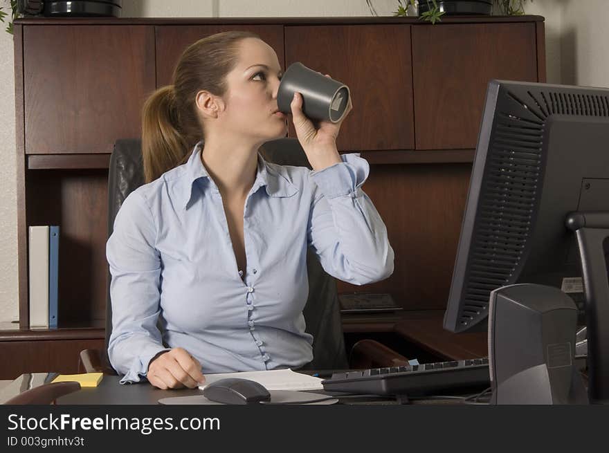 Young attractive office woman killing her time with a coffee during a downtime boredom