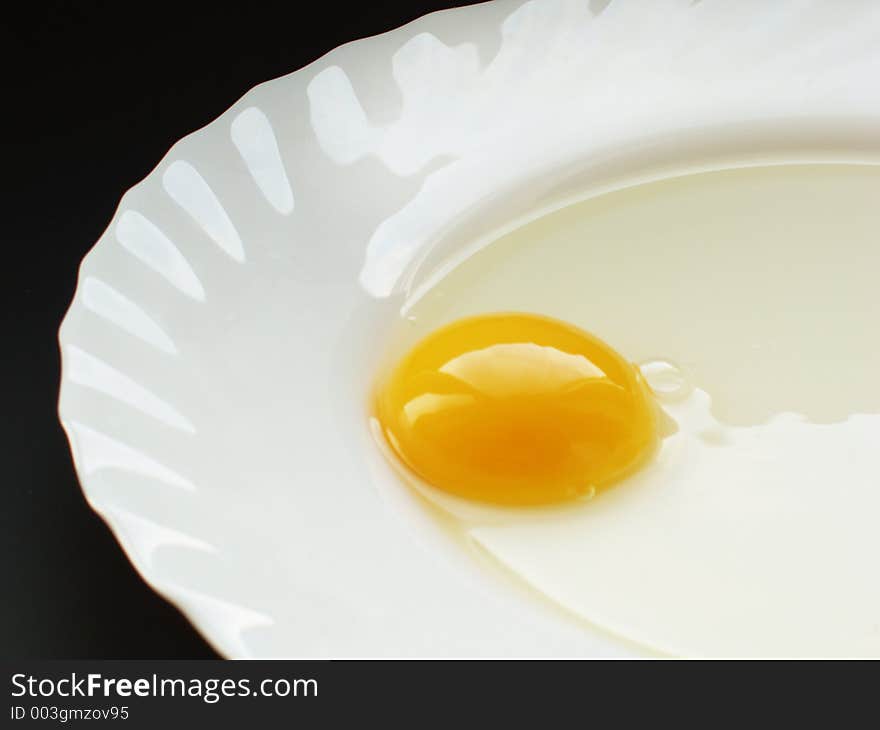 Still life with egg on white dish and black background. Still life with egg on white dish and black background