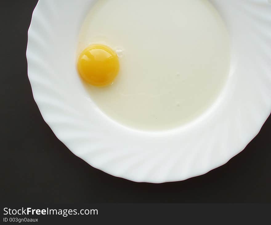 Still life with egg on white dish and black background. Still life with egg on white dish and black background