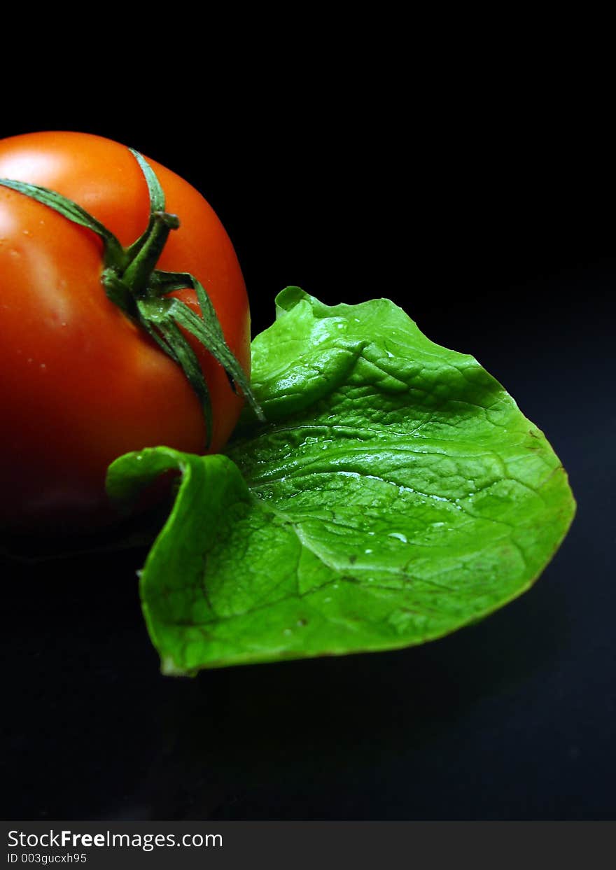 Tomato and salat on black background